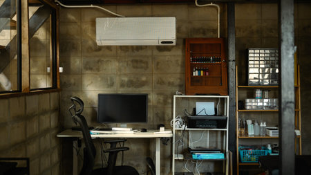 An industrial style home workspace with exposed concrete walls, computer desk and organized shelves...