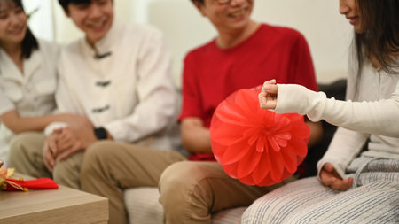 Happy family sharing laughter and stories on the sofa during Chinese New Year celebration.の写真素材