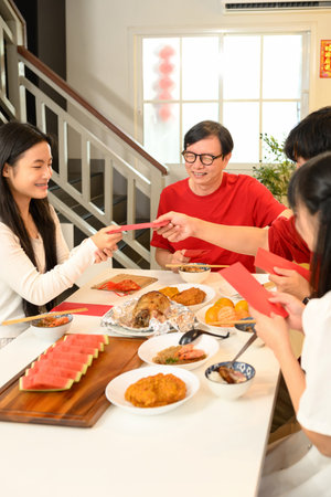 Family handing red envelop during Chinese New Year symbolizing blessings, prosperity, and good fortune for the recipient.の写真素材