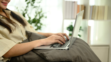 Smiling female freelancer working on her laptop in a comfortable home.