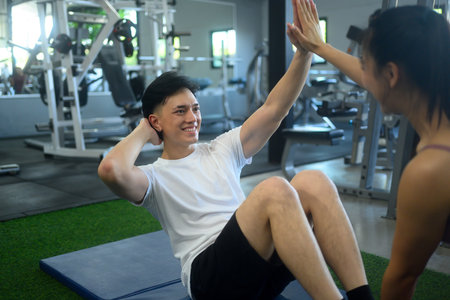 Happy athletic couple working out together in the gym..