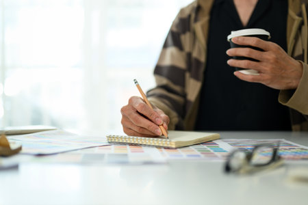 Cropped shot designer working on a new project and sketching ideas on notepad.の写真素材