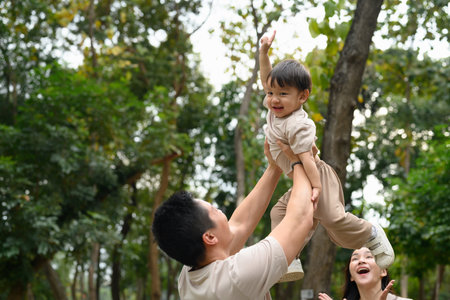 Father and little son enjoy a playful moment in a park.の写真素材