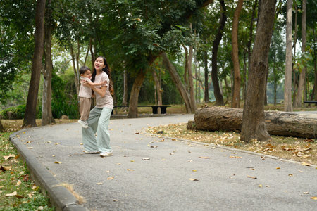 Loving mother playing with her little son on a walking path in a beautiful park.の写真素材