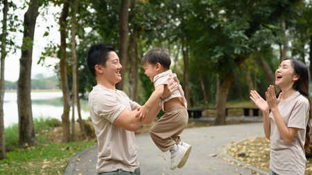 Cheerful extended family having fun in a scenic park. Outdoor leisure and family bonding concept.の写真素材
