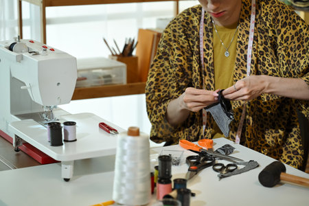 Cropped shot of stylish designer working on fabric sample in a fashion studio.の写真素材
