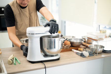 Baker mixing cookie dough with a stand mixer. Small business concept.