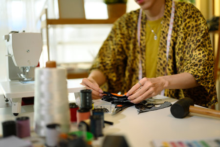 Cropped shot of young fashion designer examining fabric at creative workplace.の写真素材