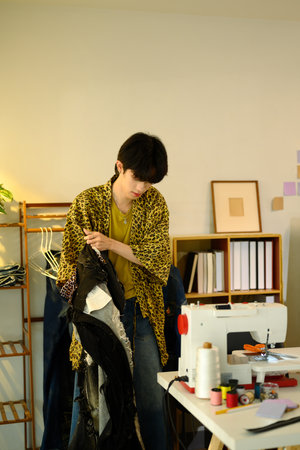 Young designer works on sustainable fashion project in a creative studio.