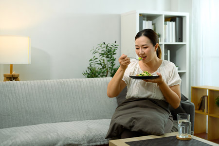 Middle aged woman enjoying a healthy meal at home.の写真素材