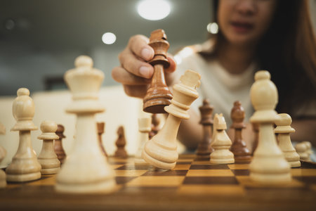 Hand knocking over the king piece in chess match. Victory, strategy and problem solving concept.