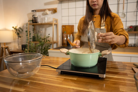 Young woman in an apron cooking a simple meal in her home kitchen.の写真素材