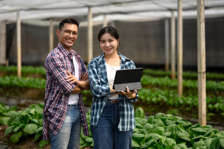 Confident farmers using digital tablet in smart greenhouse.の写真素材