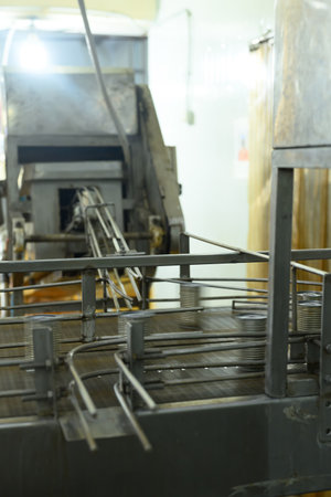 Metal cans move along an industrial conveyor system inside a seafood processing facility.