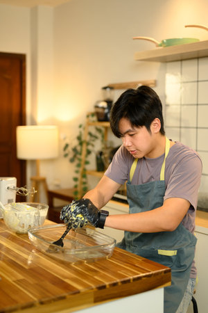 Man squeezing homemade butter to extract fresh buttermilk in a cozy kitchen.