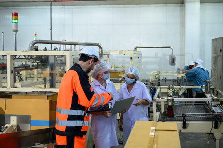 Engineers and quality control staff inspecting production process in an industrial food facility.の写真素材