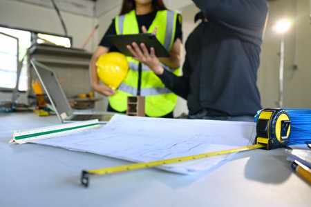 Close up of construction site desk with blueprints and tools.の写真素材