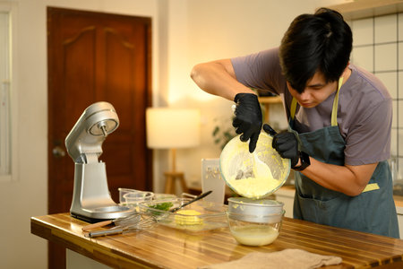 Man carefully straining fresh buttermilk from homemade butter.の写真素材