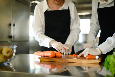 Cooking students slicing vegetables during a cooking class.の写真素材