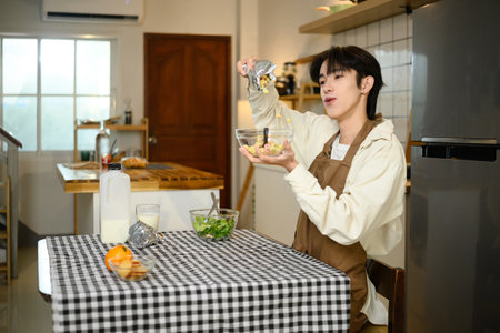 Smiling man enjoying breakfast with cereal and milk in a bright kitchen.