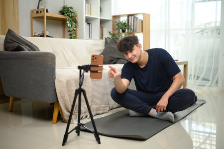 Content creator recording workout session on smartphone at home. in living room.の写真素材