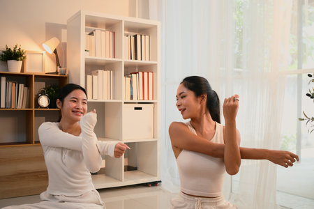 Mother and daughter enjoying a workout session together in a bright, cozy home.の写真素材