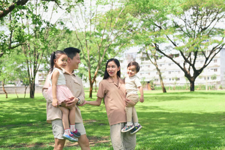 Happy family enjoying a sunny day in the park.の写真素材