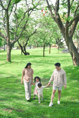 Parents enjoying a peaceful stroll with their children surrounded by vibrant nature.の写真素材