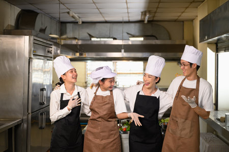 Cooking school classmates sharing a joyful conversation after class.の写真素材