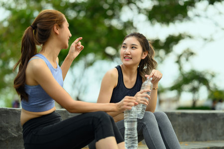 Active women in sportswear hydrating after completing their outdoor fitness routine.の写真素材