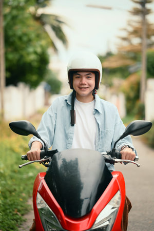 Portrait of a cheerful male motorcyclist ready to ride, captured in a suburban neighborhood.
