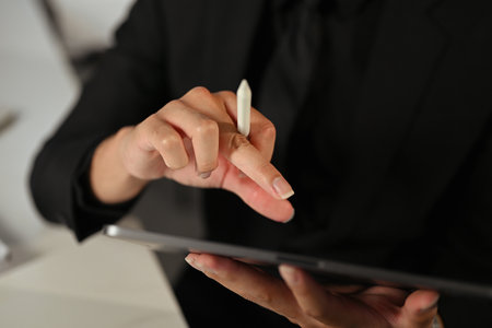 Close up shot of corporate worker interacting with tablet device in office.の写真素材