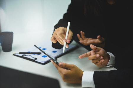 Corporate team brainstorming, using digital tablet and reports for project management.の写真素材