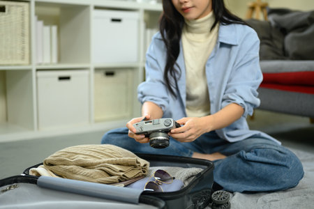 Traveler getting ready for a trip, organizing clothes and accessories in luggage.の写真素材