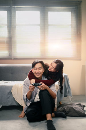 Young couple sharing joy and laughter while spending time with video games at home.の写真素材
