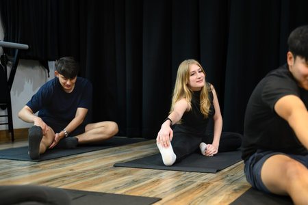 Diverse group practicing seated stretches together in a wellness studio.の写真素材