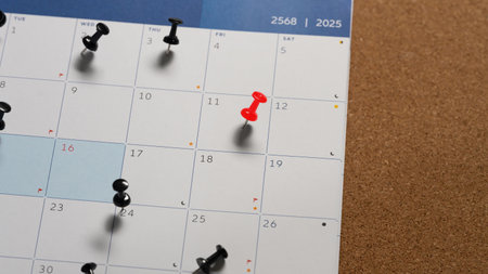 Calendar with a red push pin marking an important date, representing appointment or planning.