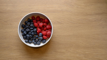 Raspberry And Blueberry On Bowl With Top view And Copy Space.