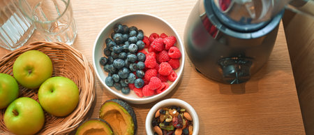 Healthy lifestyle setup in the kitchen. Fresh fruits apples, blueberries, raspberries, and avocado arranged beside a blender, prepared for making a homemade smoothie.の写真素材