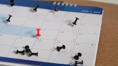 Calendar with red push pin marking an important date. Appointment reminder and planning concept.の写真素材