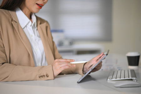 Closeup businesswoman working on digital tablet in office, representing modern career, technology, and professional lifestyle.の写真素材