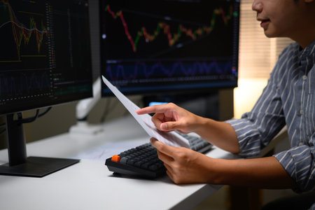 Photo Set of Close up A young trader working with financial charts on a computer at home, Future job opportunities in digital markets and stock exchange.の写真素材