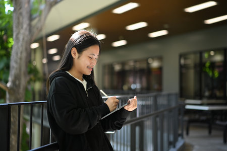 A teenage girl enjoying her creativity through digital art on a tablet.の写真素材