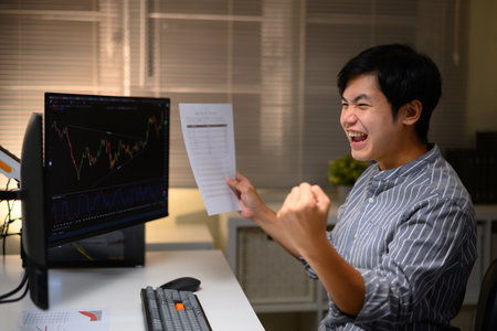Excited trader celebrating success after profitable trade, showing joy, motivation, and achievement.の写真素材