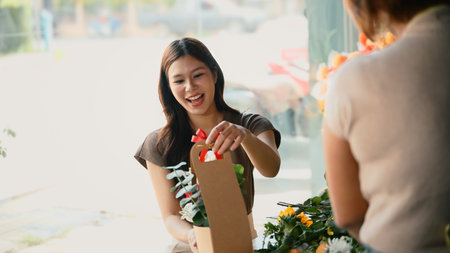 Enjoyment young woman florist arranging plants in flower shop.の写真素材