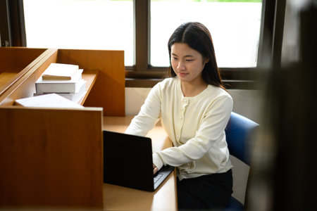 Teenage girl education concept. Her using laptop in library.の写真素材