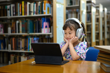 Photo set Asian little girl learning on tablet in library, smiling happiness.