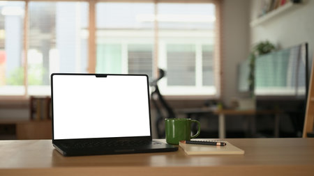 White office desk with computer laptop, plant and document at home office.