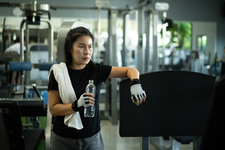 Woman resting with water bottle after gym training.の写真素材