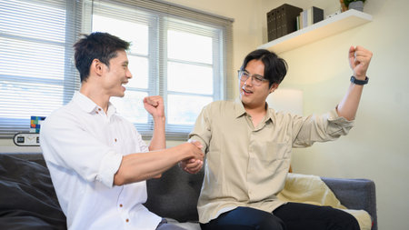 Photo Set Of Two Excited Male Friends Celebrate Watching Sports On Television At Home.の写真素材